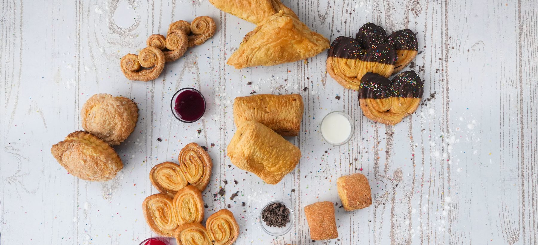 Surtido de hojaldres, corazones y pasteles de Milhojaldres sobre mesa de madera